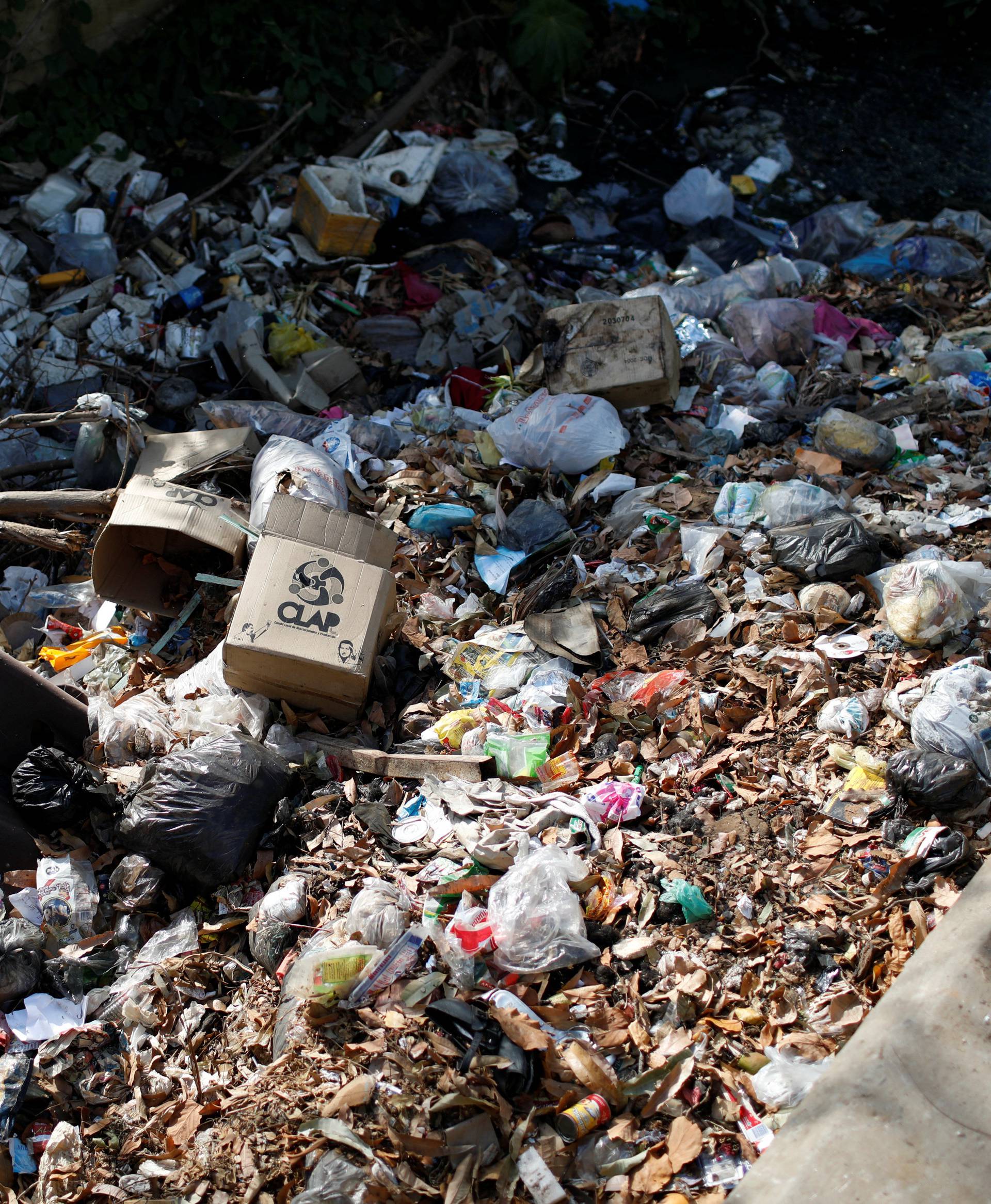 A CLAP box, a Venezuelan government handout of basic food supplies, is seen amid garbage dump along a canal in Maracaibo