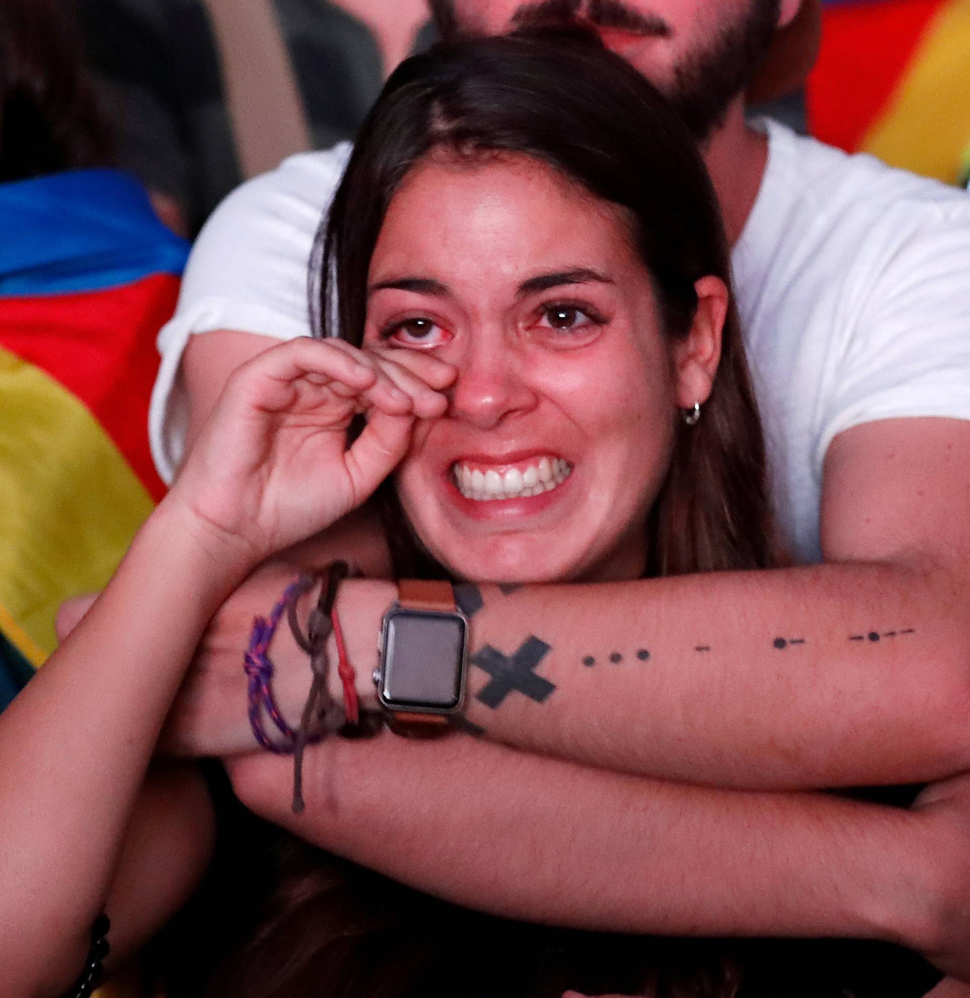 Woman reacts while watching Catalonian regional parliament session on giant screen in Barcelona