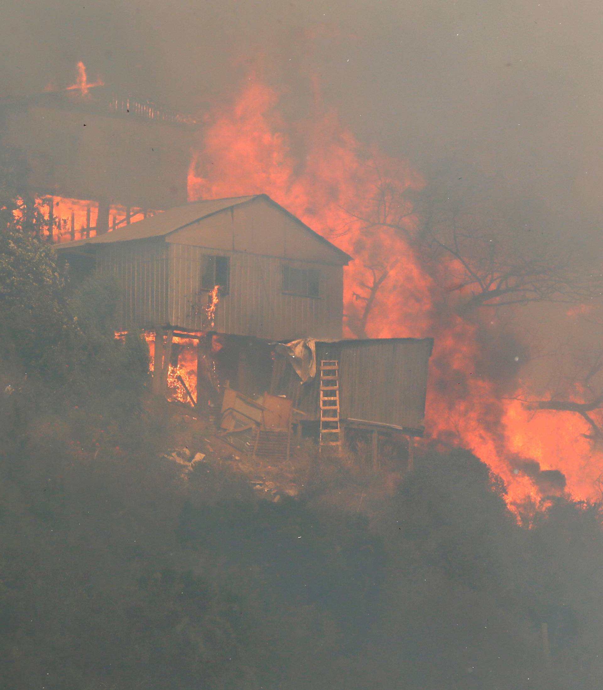 Fire burns a house on a hill, where more than 100 homes were burned due to forest fire but there have been no reports of death, local authorities said in Valparaiso, Chile