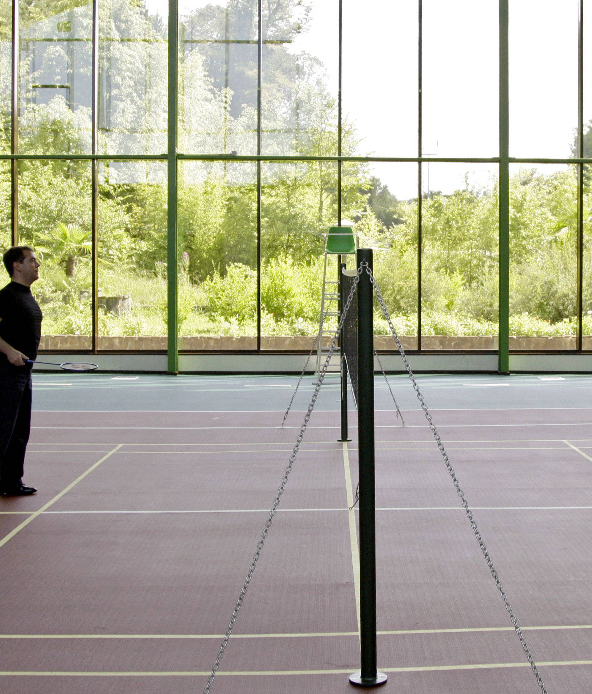 FILE PHOTO: Russia's President Dmitry Medvedev and Prime Minister Vladimir Putin play badminton, as Medvedev's golden retriever Aldo runs over the court in the Black Sea resort of Sochi