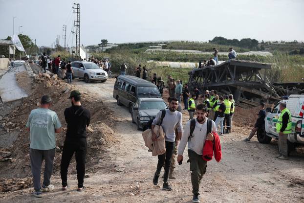 Displaced people cross the bridge linking southern Lebanon to the rest of the country, which was hit earlier in an Israeli strike, in Qasmiyeh