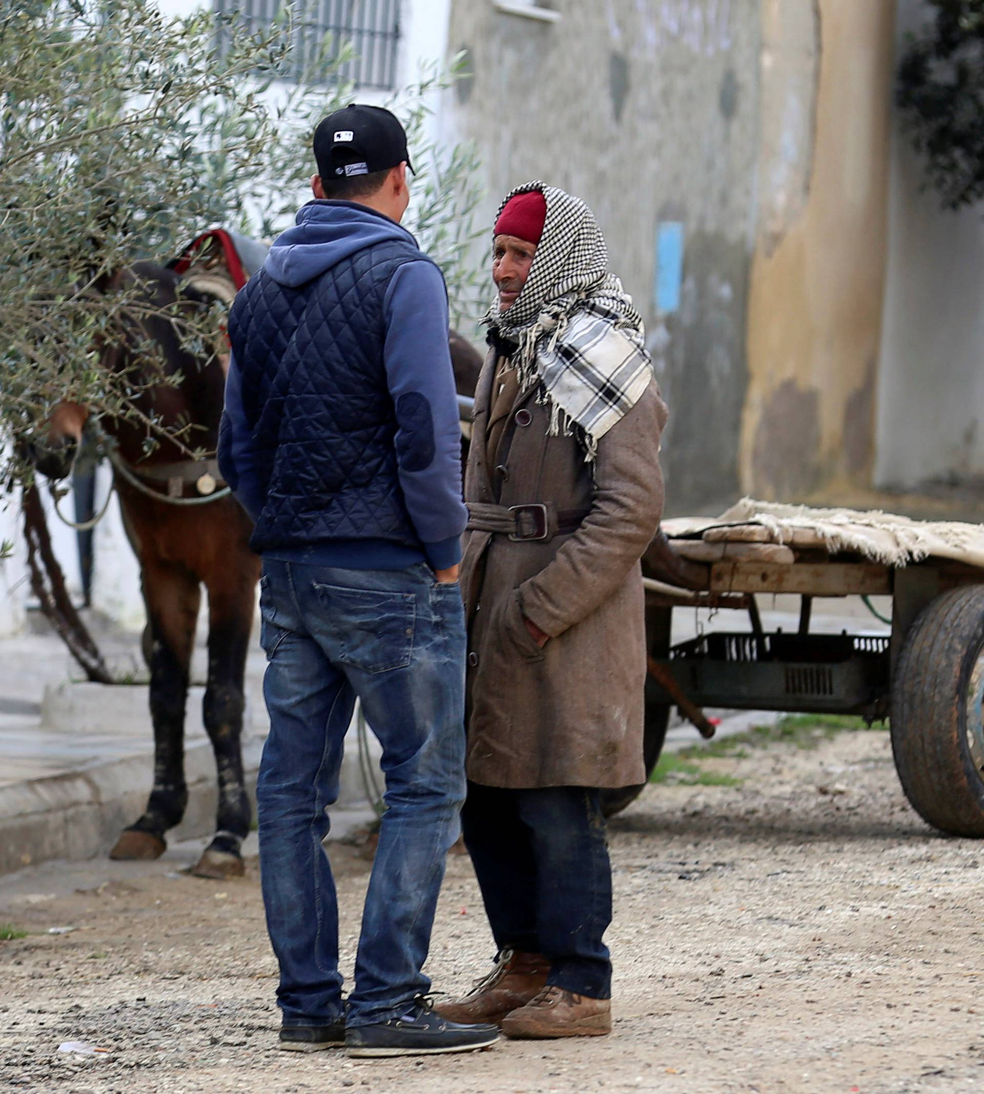 Mustapha Amri, father of suspect Anis Amri who is sought in relation with the truck attack on a Christmas market in Berlin, speaks with his son Walid near their home in Oueslatia, Tunisia