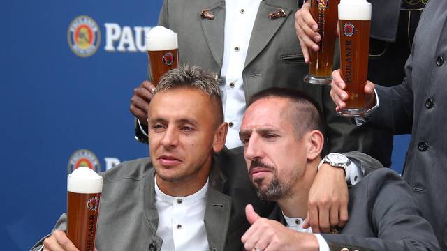 Bayern Munich's soccer team wearing traditional attire, toasts with beer during photocall in Munich