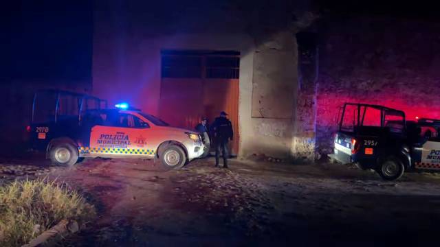 Police officers and vehicles positioned outside the site of a party where an armed group opened fire on partygoers, in Salvatierra