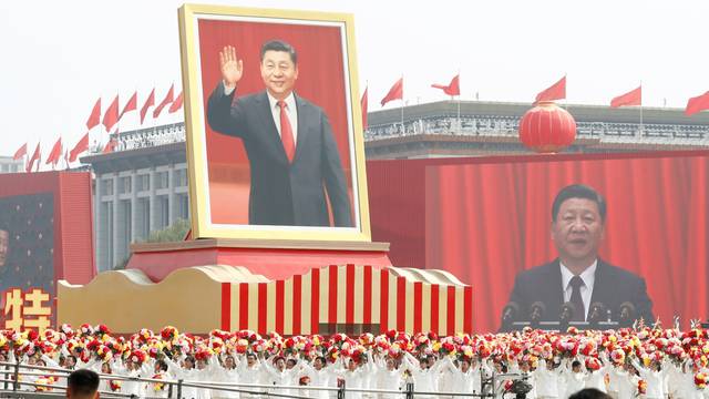 Performers travel past Tiananmen Square with a float showing Chinese President Xi during the parade marking the 70th founding anniversary of People's Republic of China