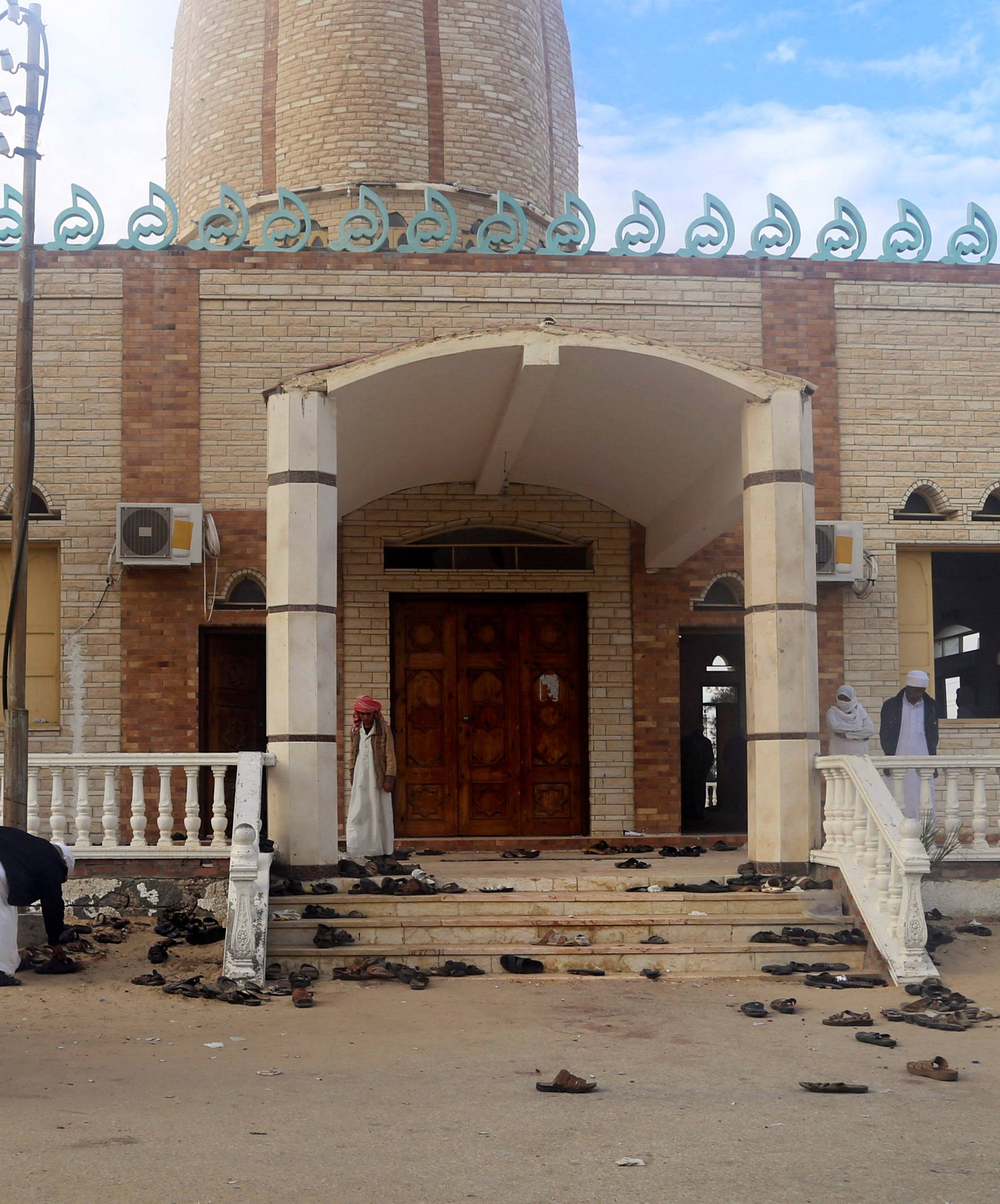 People stand outside Al Rawdah mosque, where a bomb exploded, in Bir Al-Abed, Egypt