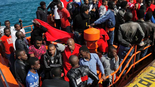 Migrants, intercepted aboard two dinghies off the coast in the Strait of Gibraltar, wait on a rescue boat to disembark after arriving at the port of Tarifa