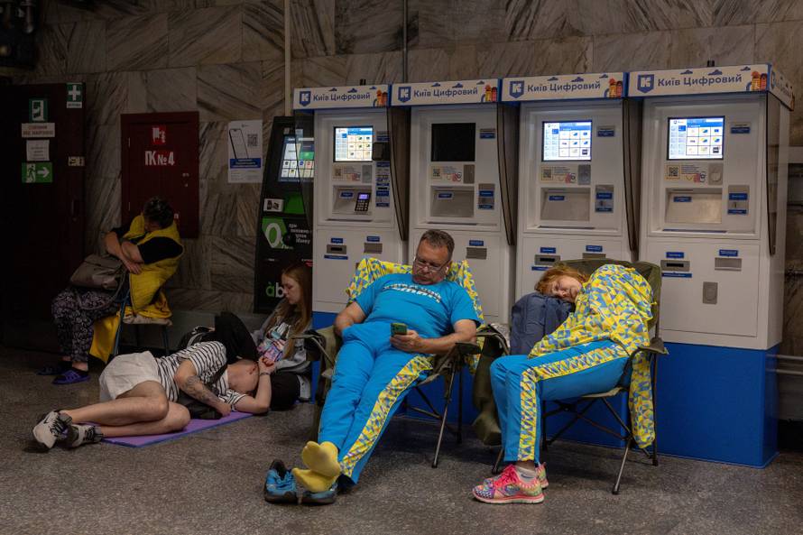 People take shelter in a metro station during Russian drone and missile strikes in Kyiv