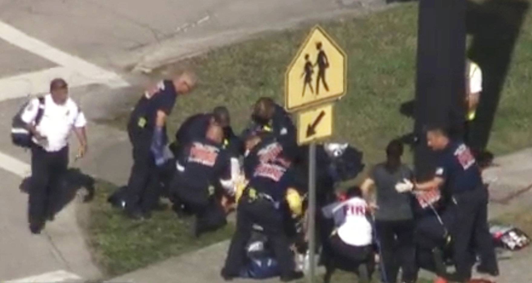 Rescue workers deal with a victim near Marjory Stoneman Douglas High School during a shooting incident in Parkland