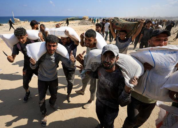 Palestinians gather to receive aid supplies amid a hunger crisis, in Beit Lahia