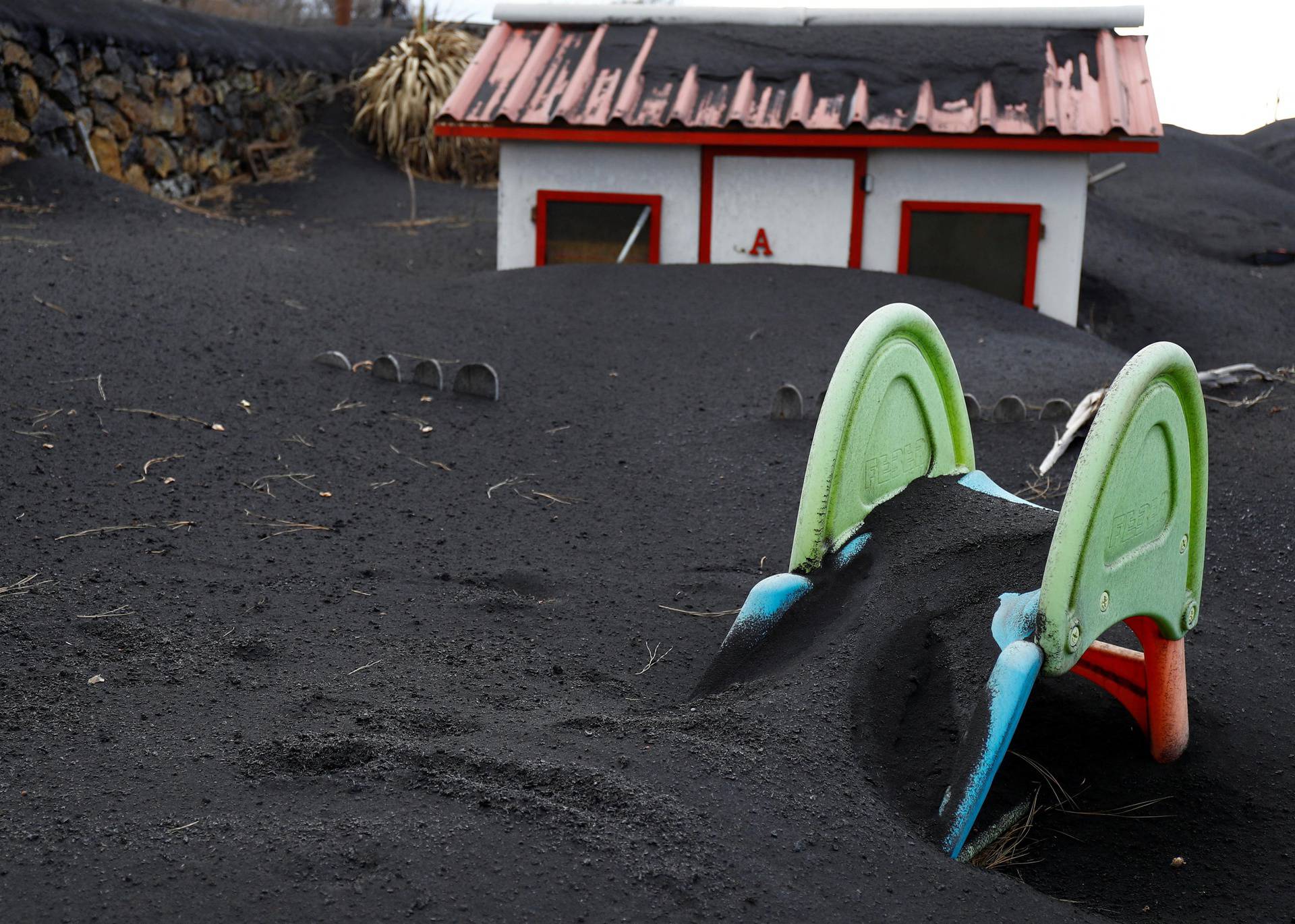 A slide is seen buried in the ash from the Cumbre Vieja volcano in Las Manchas