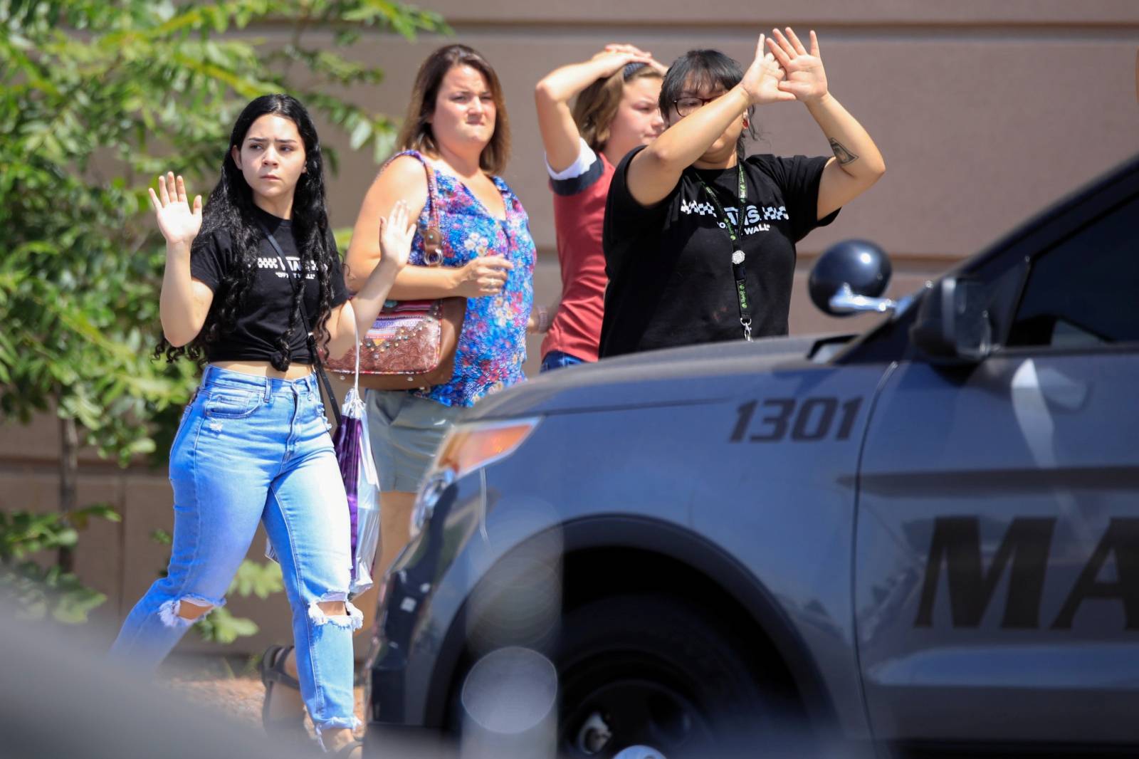 Shoppers exit with their hands up after a mass shooting at a Walmart in El Paso