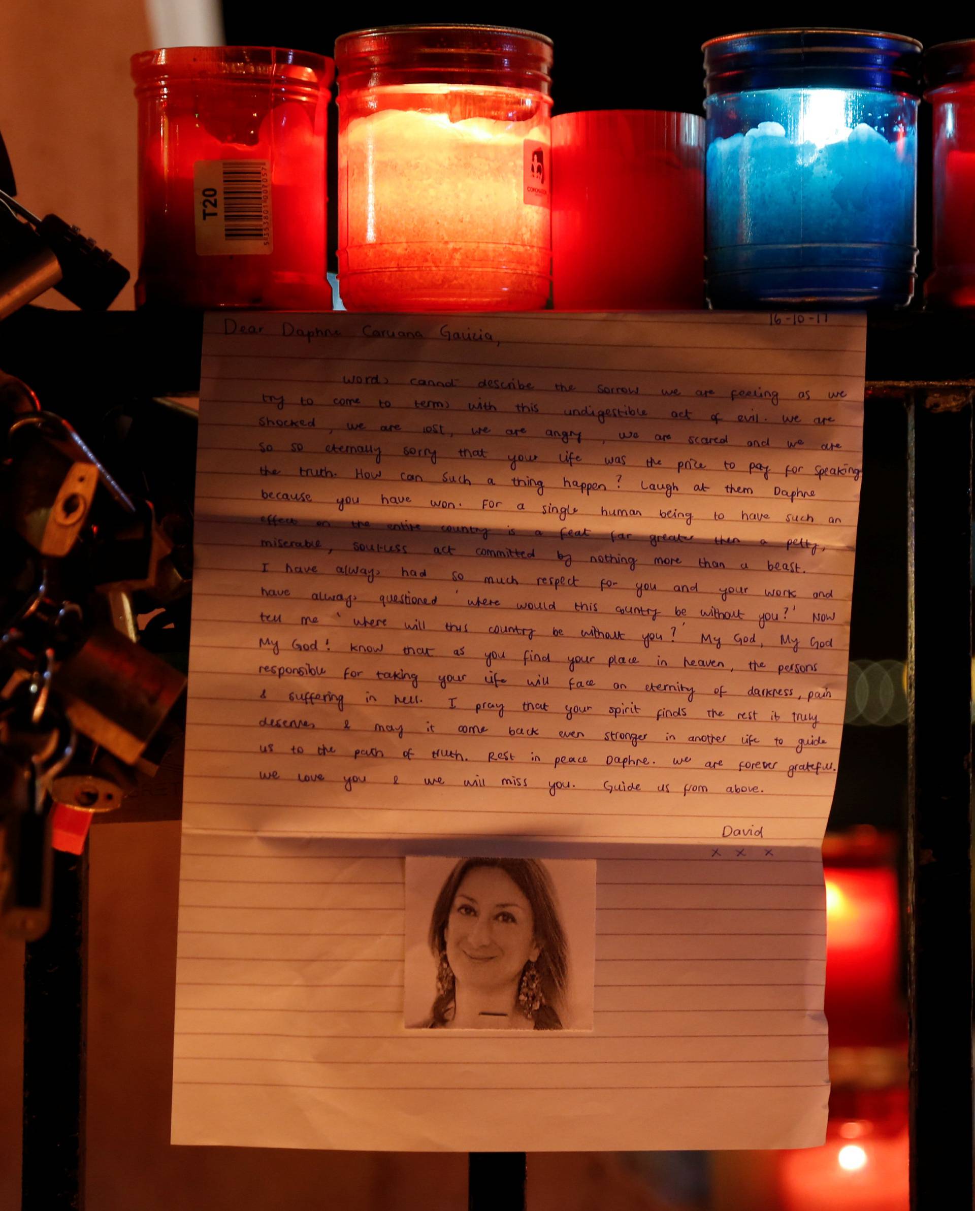 A letter to investigative journalist Daphne Caruana Galizia, assassinated in a car bomb attack on Monday, is seen on the Love monument during a silent candlelight vigil to protest against her murder, in St Julian's