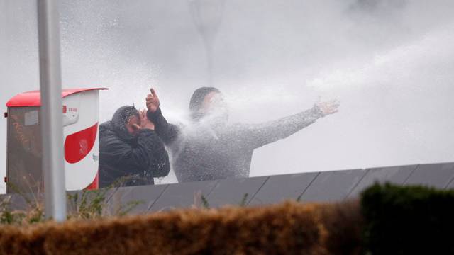 Far-right supporters are sprayed with a water cannon during a protest against Marrakesh Migration Pact in Brussels