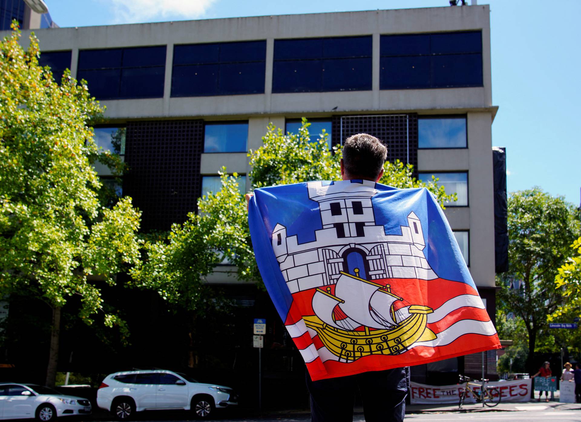 Novak Djokovic's fan Billy Misovic flies a Serbian flag in front of the Park Hotel, believed to be holding the Serbian tennis player in Melbourne