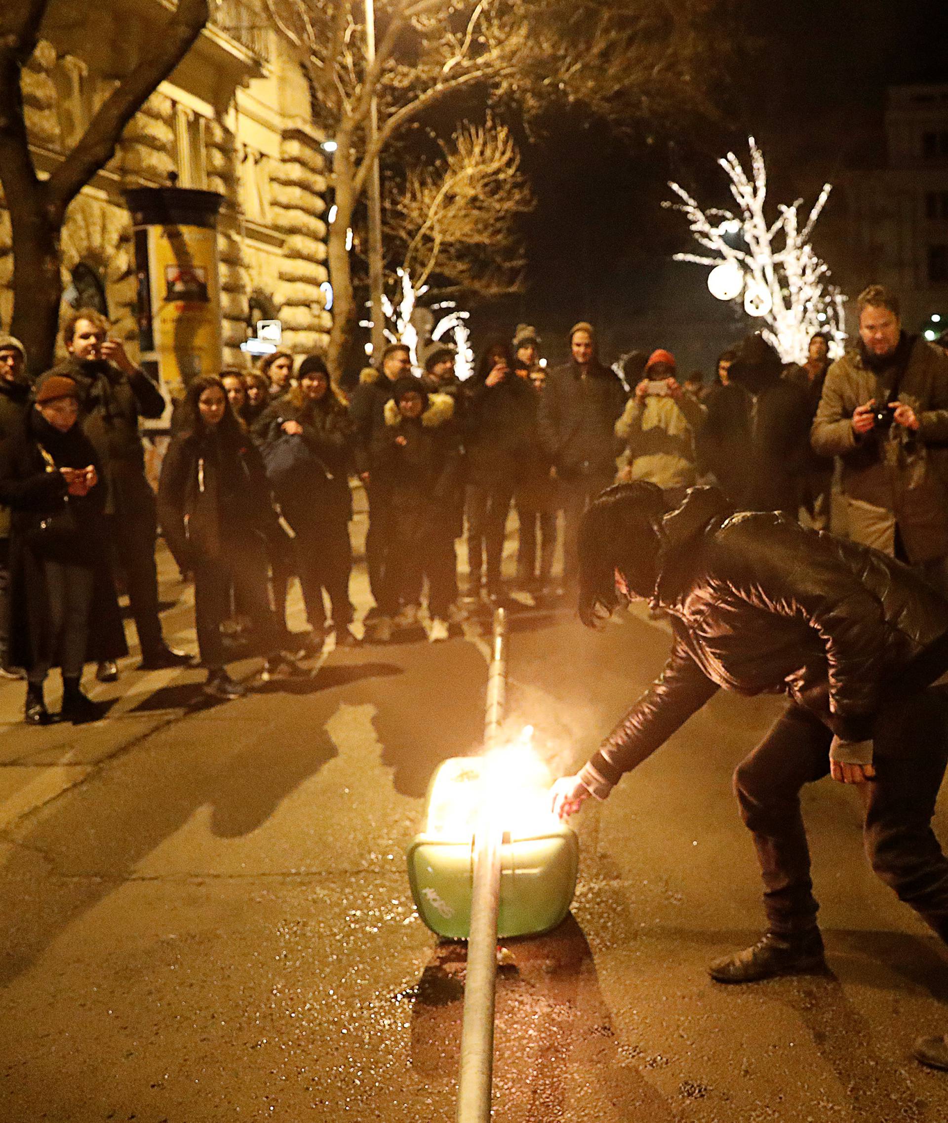 A demonstrator lights a bin on fire during a protest against the new labour law in front of the Parliament building in Budapest