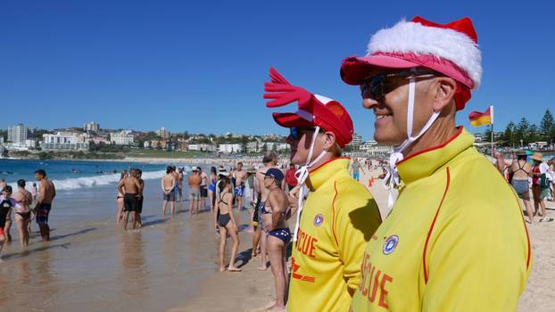 Simon (L) and Victor (R), volunteer life guards from North Bondi Surf Life Saving Club, keep an eye on swimmers enjoying Christmas day on Bondi Beach