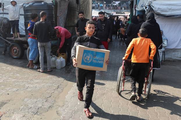 FILE PHOTO: Palestinians receive aid from UNRWA in Deir Al-Balah, central Gaza Strip