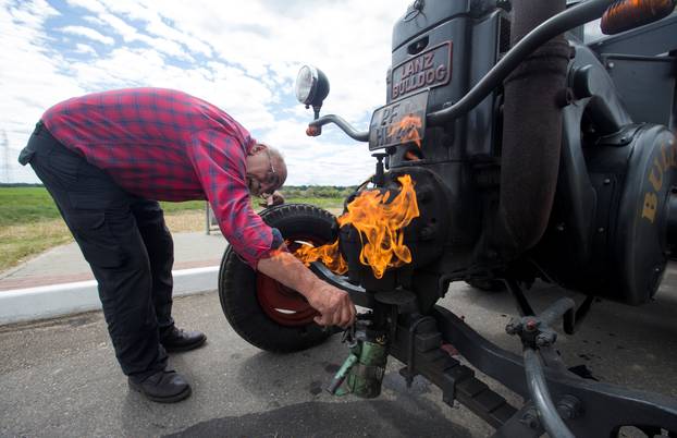 Soccer fan from Pforzheim, Germany, Wirth, 70, warms his tractor