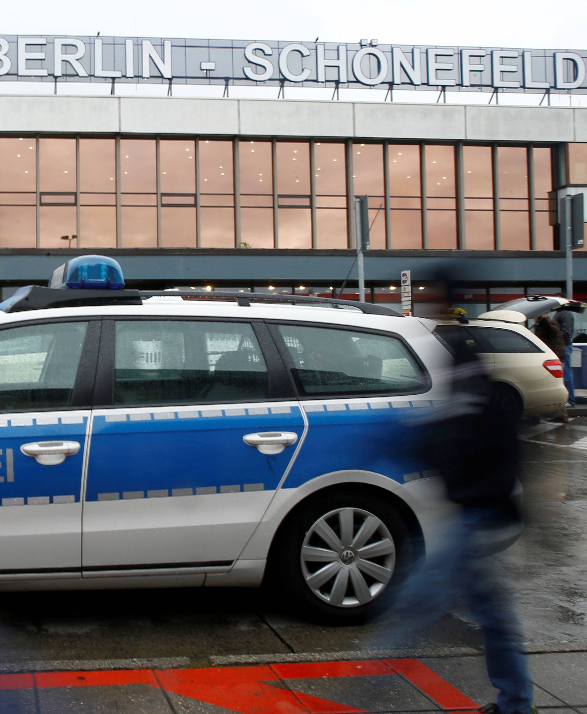 A police car stands in front of the main terminal of Berlin-Schoenefeld airport, in Schoenefeld