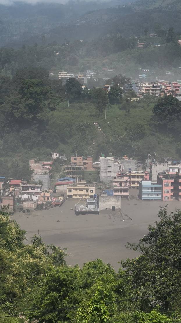 Partially submerged buildings along the riverbank due to a flash flood in Nuwakot district