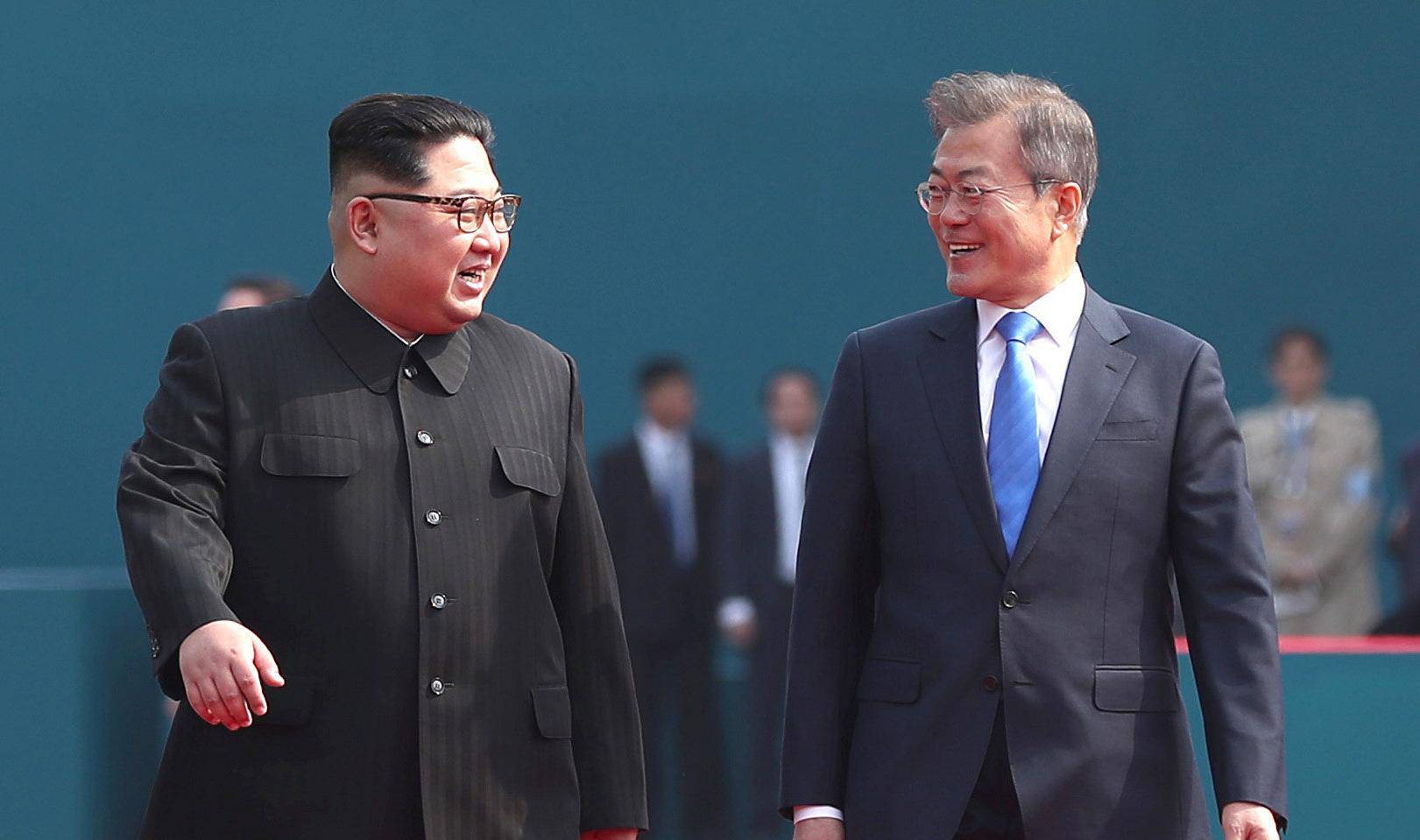 South Korean President Moon Jae-in walks with North Korean leader Kim Jong Un during their meeting at the truce village of Panmunjom