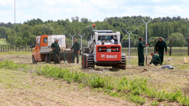 Workers install poles for fence near Sudargas border crossing point with Russia in Ramoniskiai