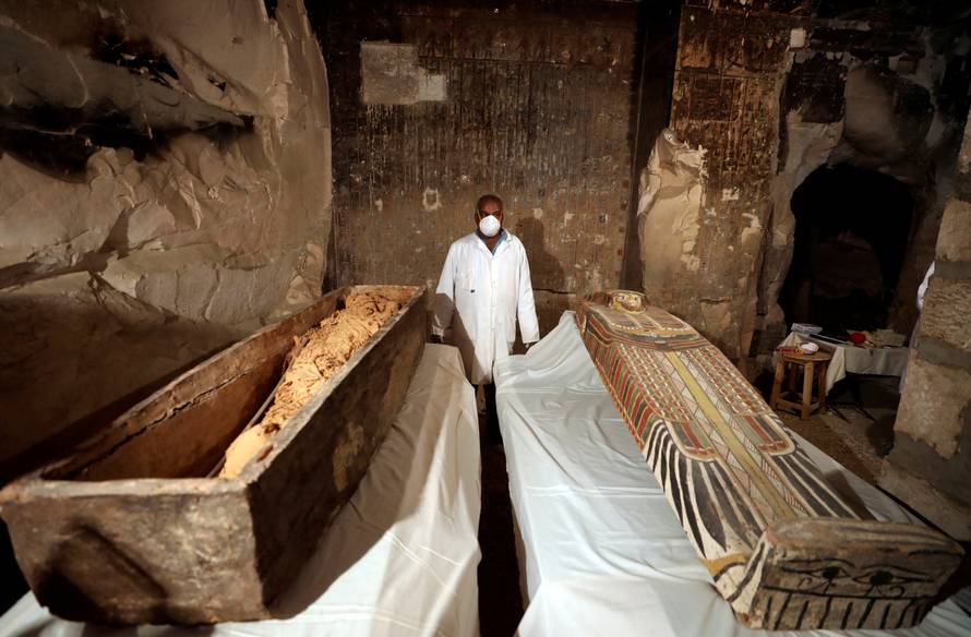 An archaeologist  stands near an intact sarcophagus inside the tomb TT33 in Luxor
