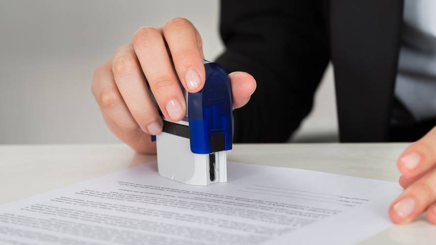 Cropped,Image,Of,Young,Businesswoman,Stamping,Contract,Document,At,Office