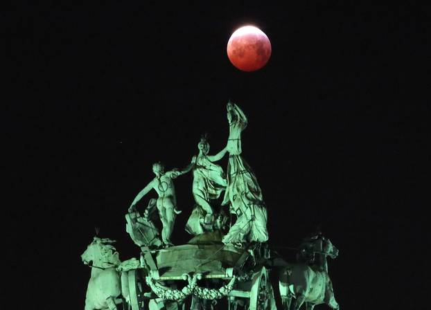 The moon is seen beside a quadriga on the top of the Cinquantenaire arch during a total lunar eclipse known as the "Super Blood Wolf Moon", in Brussels