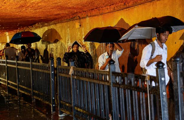 People walk in a waterlogged subway after heavy rains in Mumbai