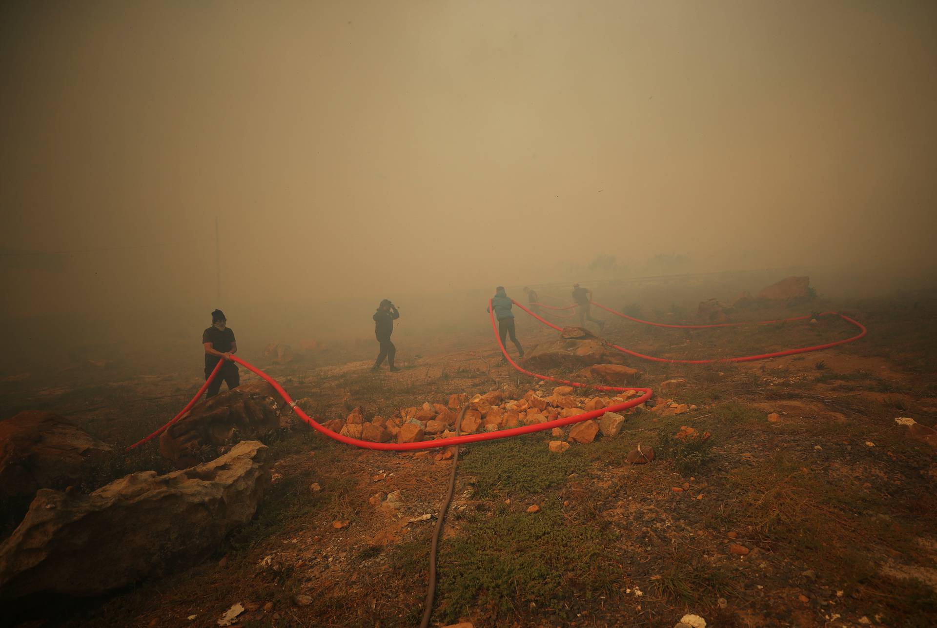 Firefighters battle to contain a fire fanned by strong winds on the slopes of Table Mountain in Cape Town