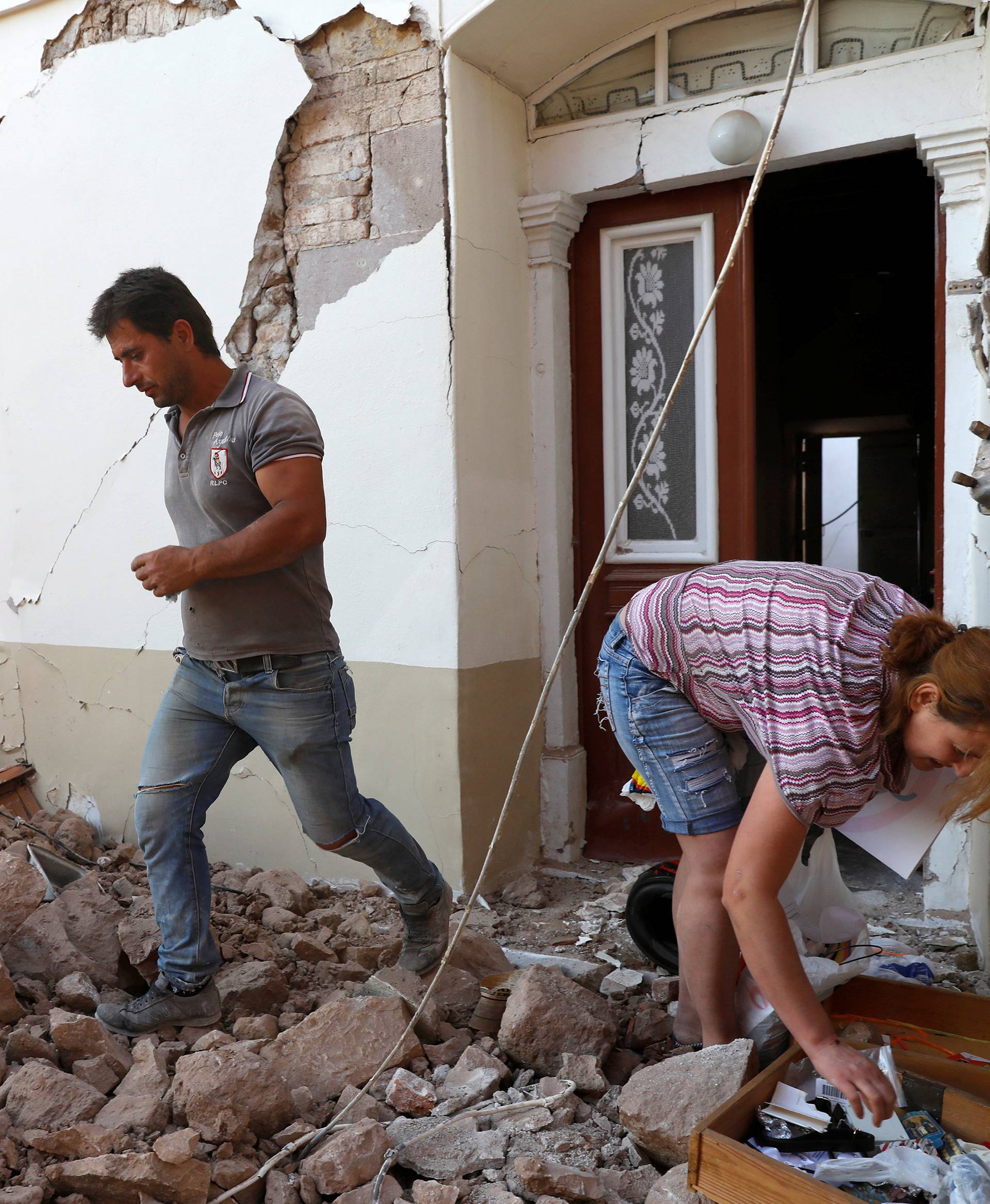 People evacuate from their damaged house at the village of Vrissa on the Greek island of Lesbos, Greece, after a strong earthquake shook the eastern Aegean