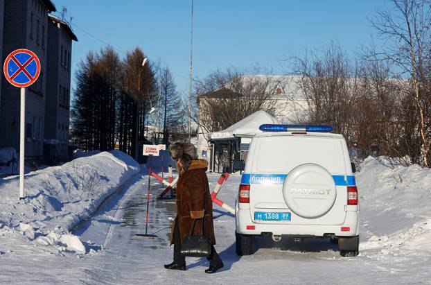 A woman walks past a police car outside the penal colony where Alexei Navalny served his sentence in Kharp