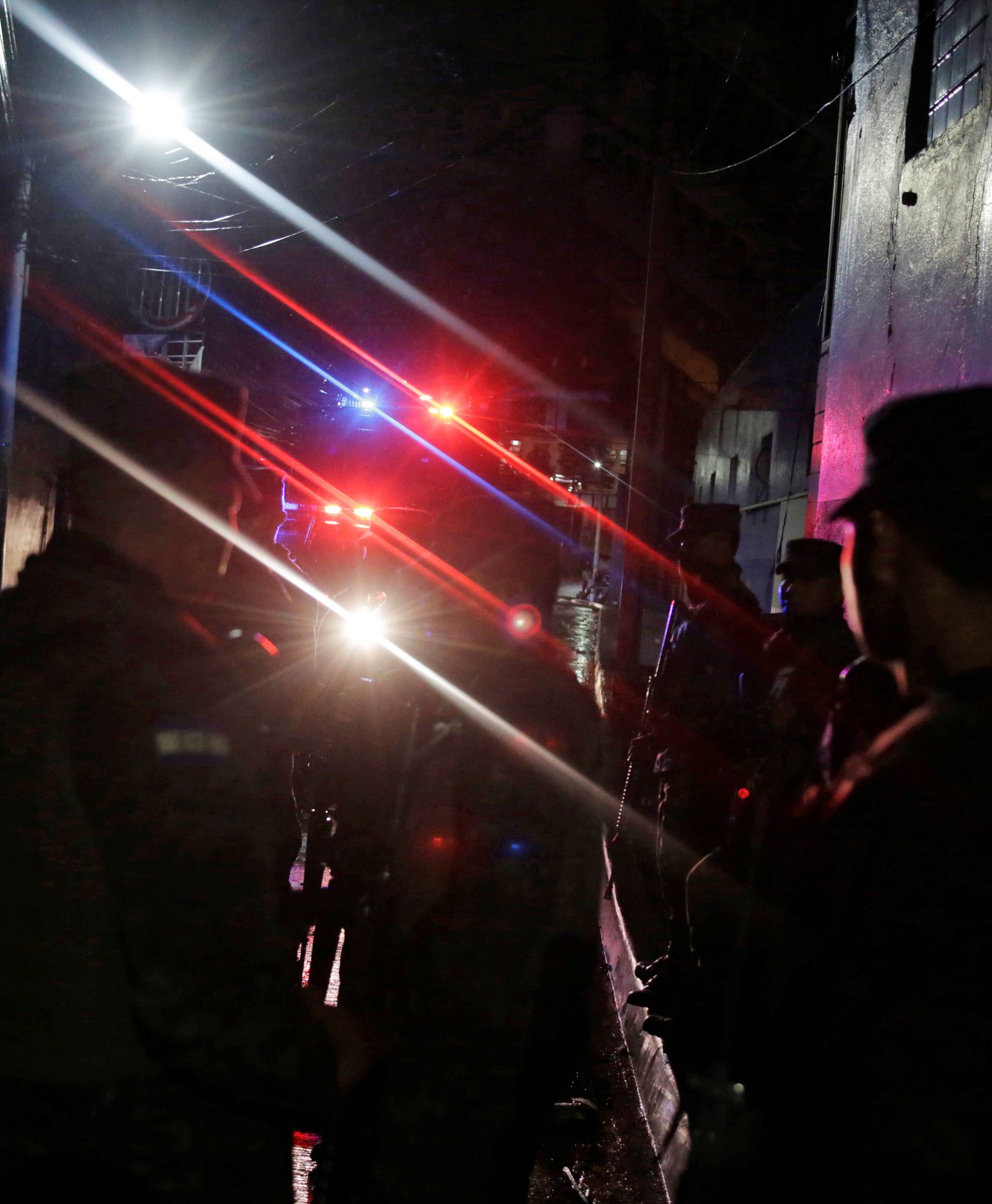 Police officers keep watch after three people died in riots before a soccer match when the fans attacked a bus carrying one of the teams, on the outskirts of the National Stadium in Tegucigalpa