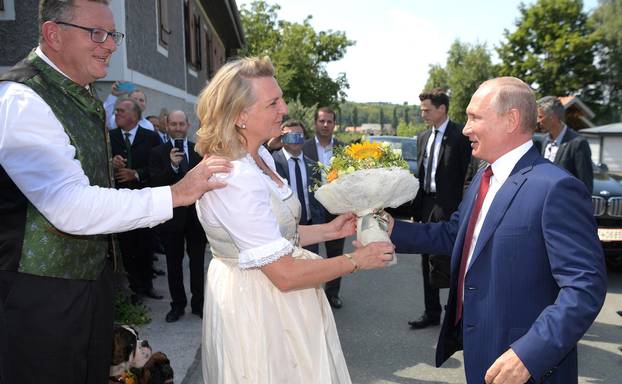 Gamlitz, Austria. 18 August 2018. Russian President Vladimir Putin presents flowers to the bride, Austrian Foreign Minister Karin Kneissl as the groom,  businessman Wolfgang Meilinger, left, looks on August 18, 2018 in Gamlitz, Austria. Putin attended the