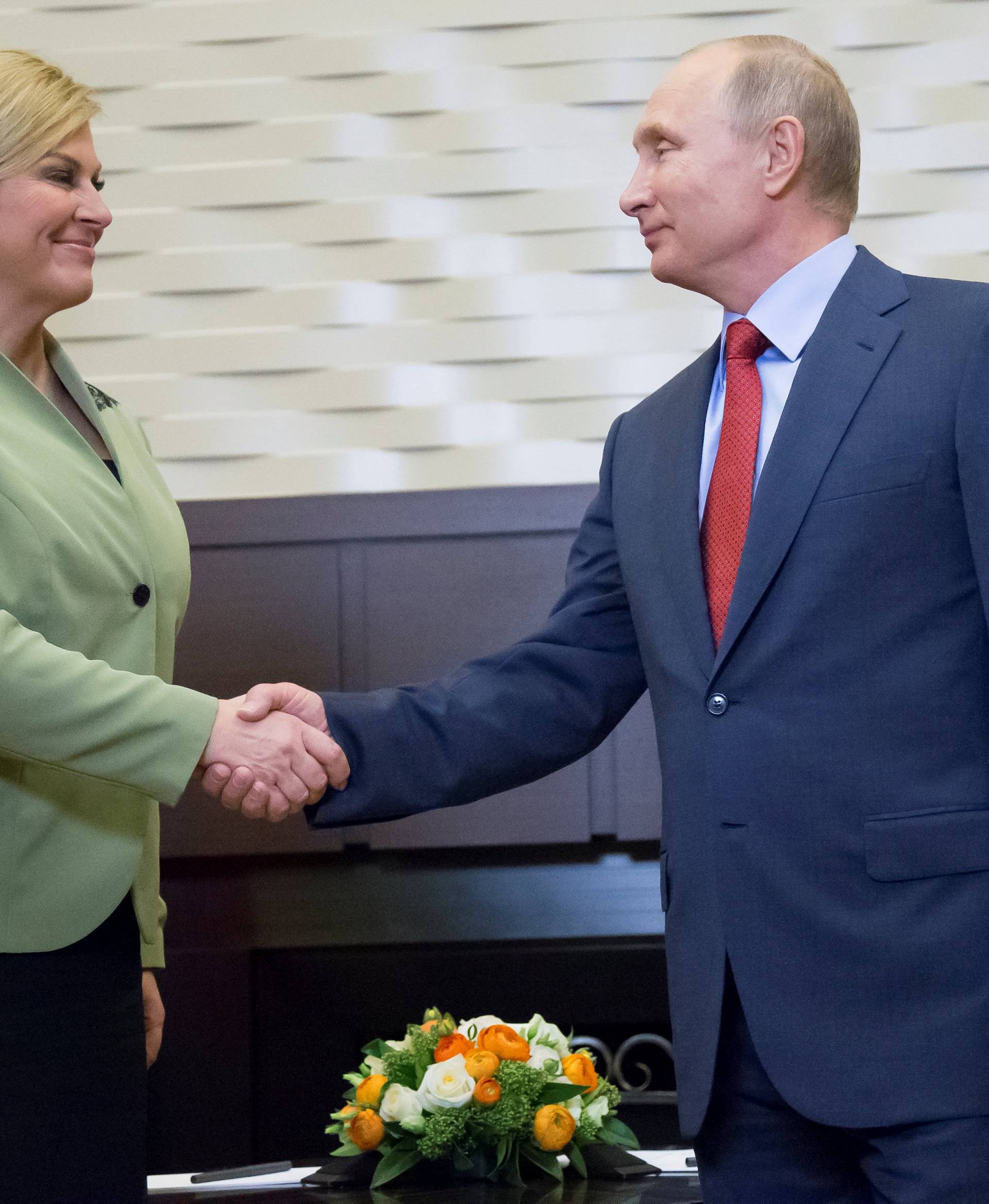 Putin shakes hands with Croatian President Grabar-Kitarovic during their meeting in Sochi