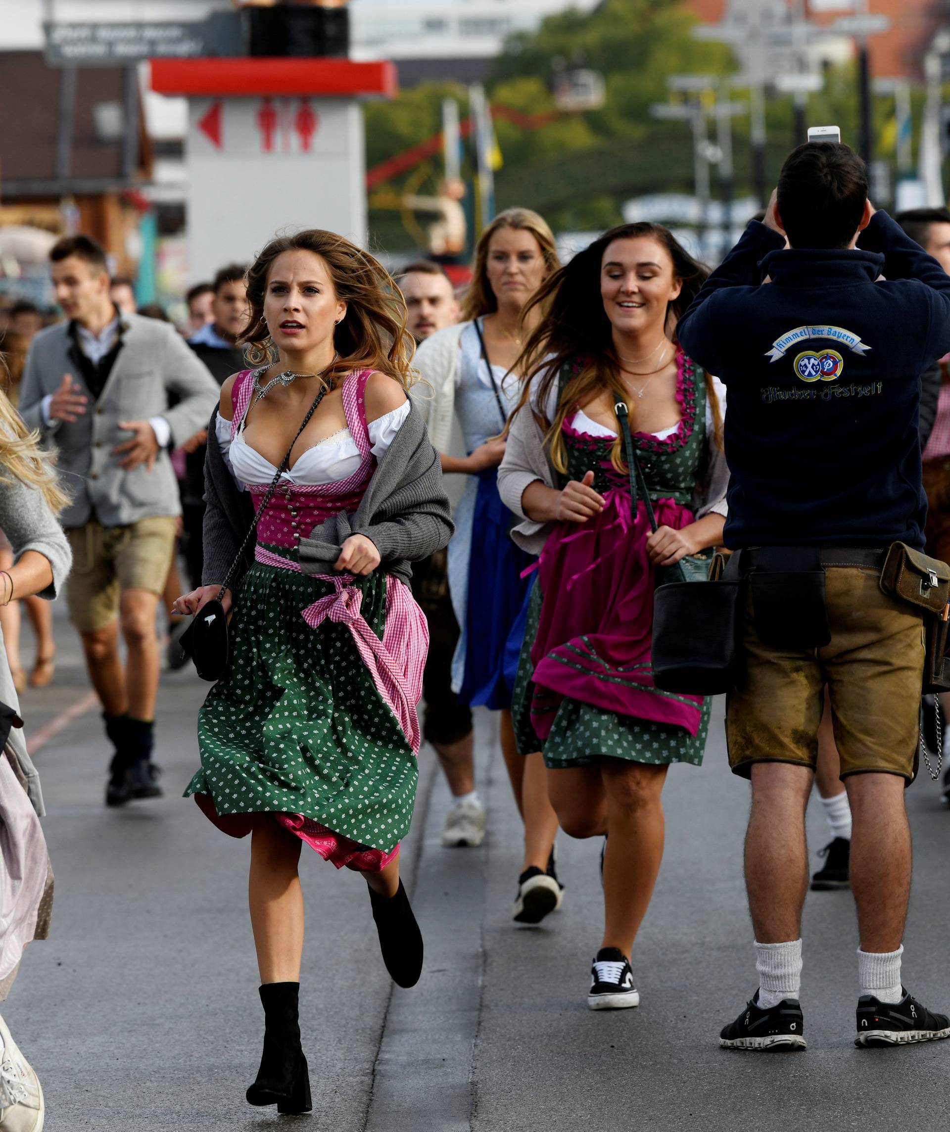 Visitors run to get a spot at the Oktoberfest area at the opening day of the 185th Oktoberfest in Munich