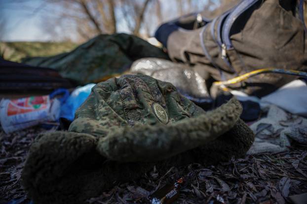 A Russian military winter hat lies among belongings Russian soldiers left behind after Ukrainian forces routed their armoured vehicles, as Russia's attack on Ukraine continues, outside Brovary