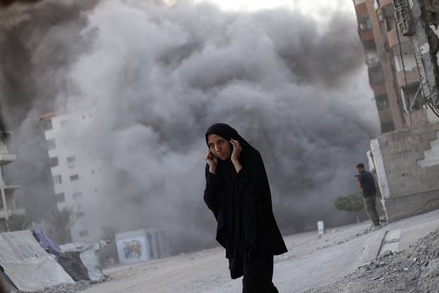 Residential building collapses after an Israeli air strike, in Gaza City