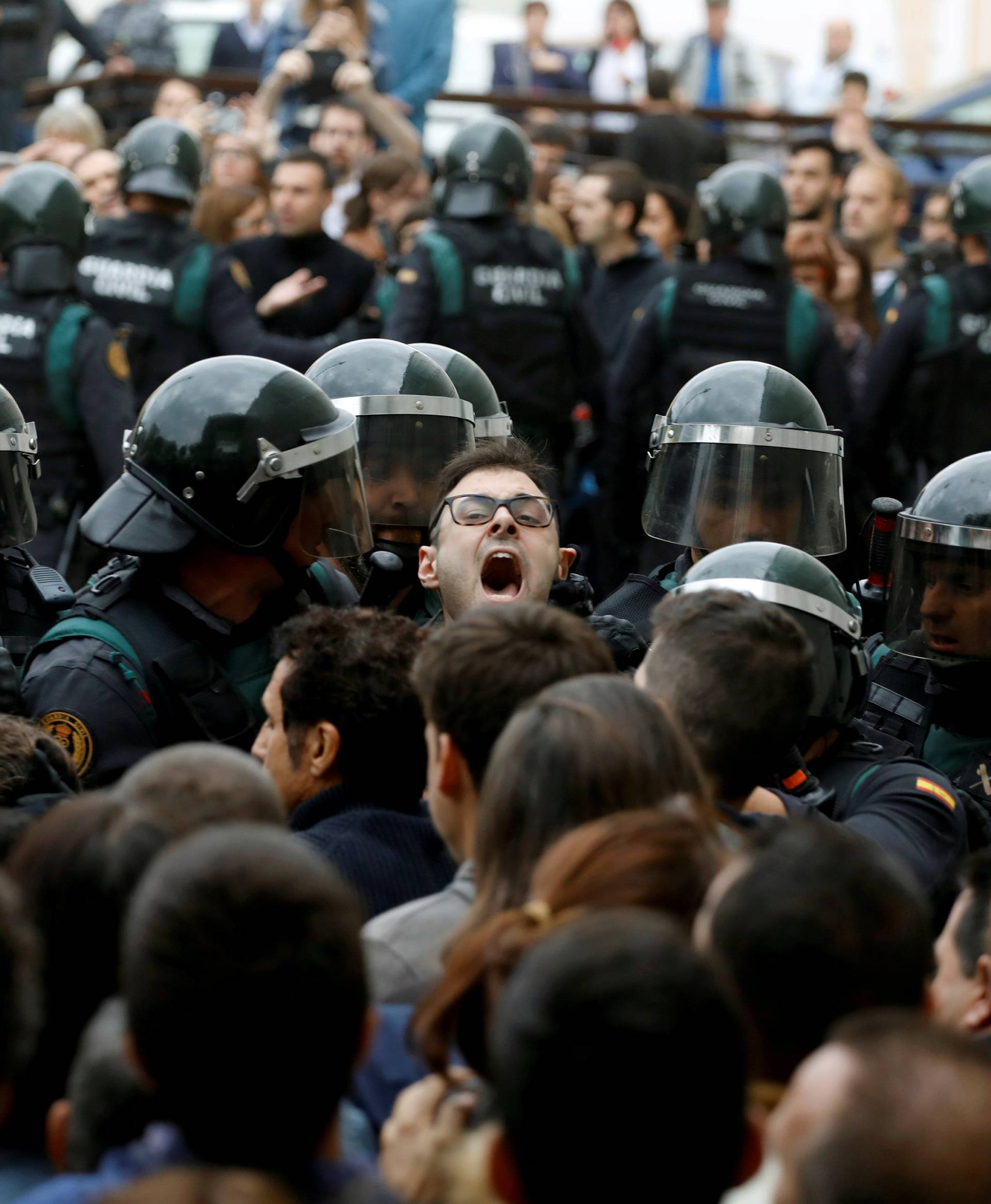 Scuffles break out as Spanish Civil Guard officers force their way through a crowd and into a polling station for the banned independence referendum in Sant Julia de Ramis