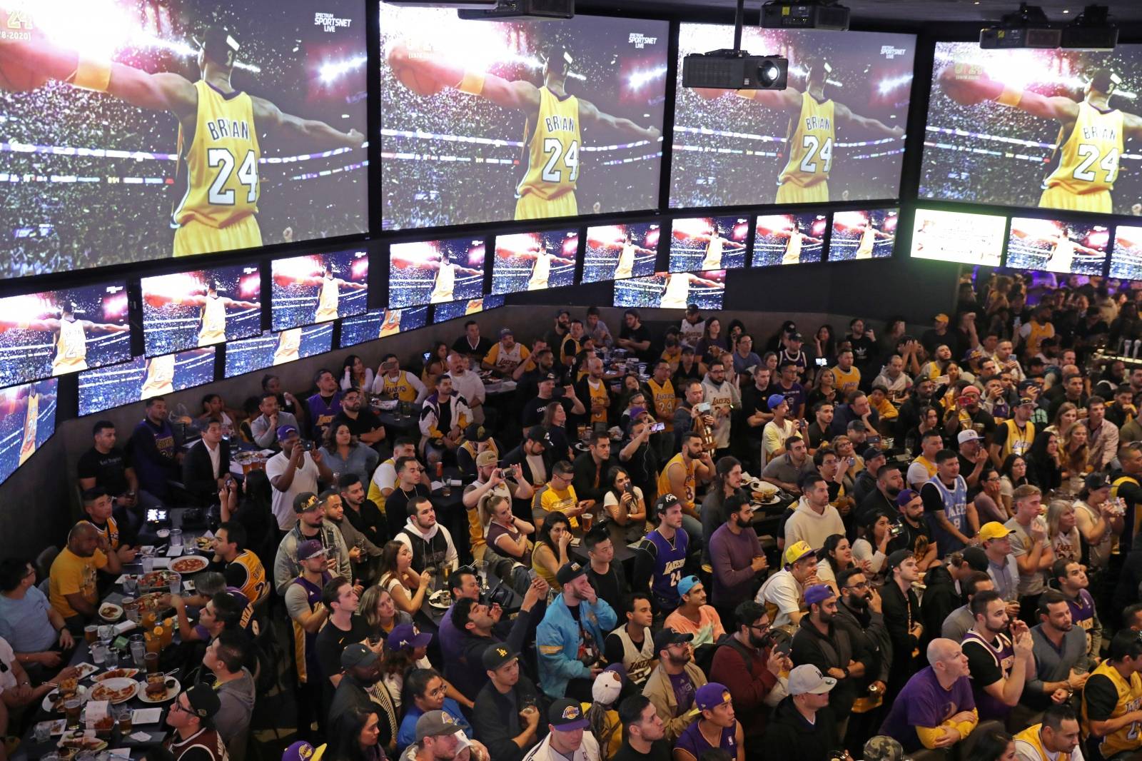 An image of Kobe Bryant appears on screens at Tom’s Watch Bar as fans watch a televised Los Angeles Lakers home game