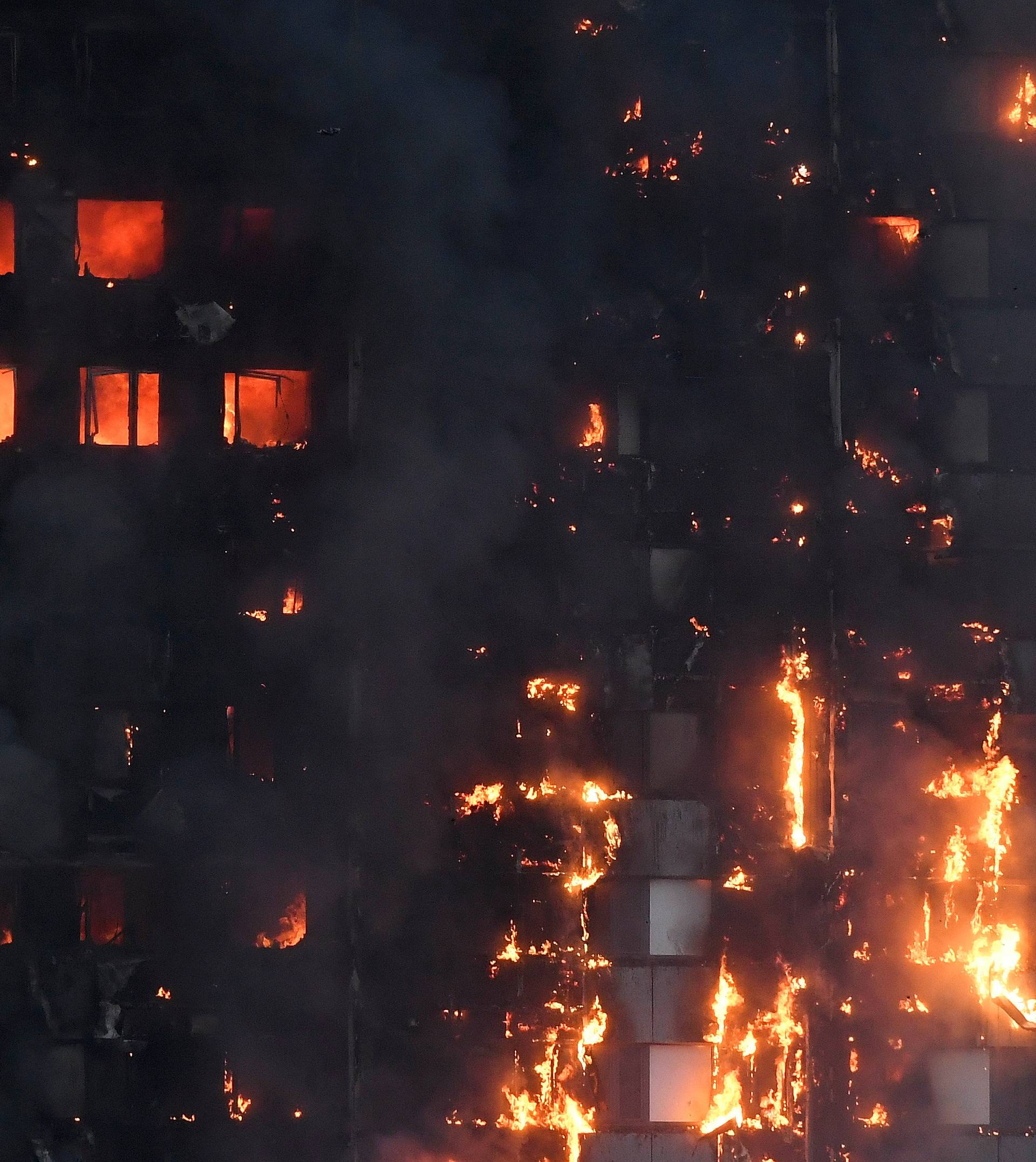 Flames and smoke billow as firefighters deal with a serious fire in a tower block at Latimer Road in West London