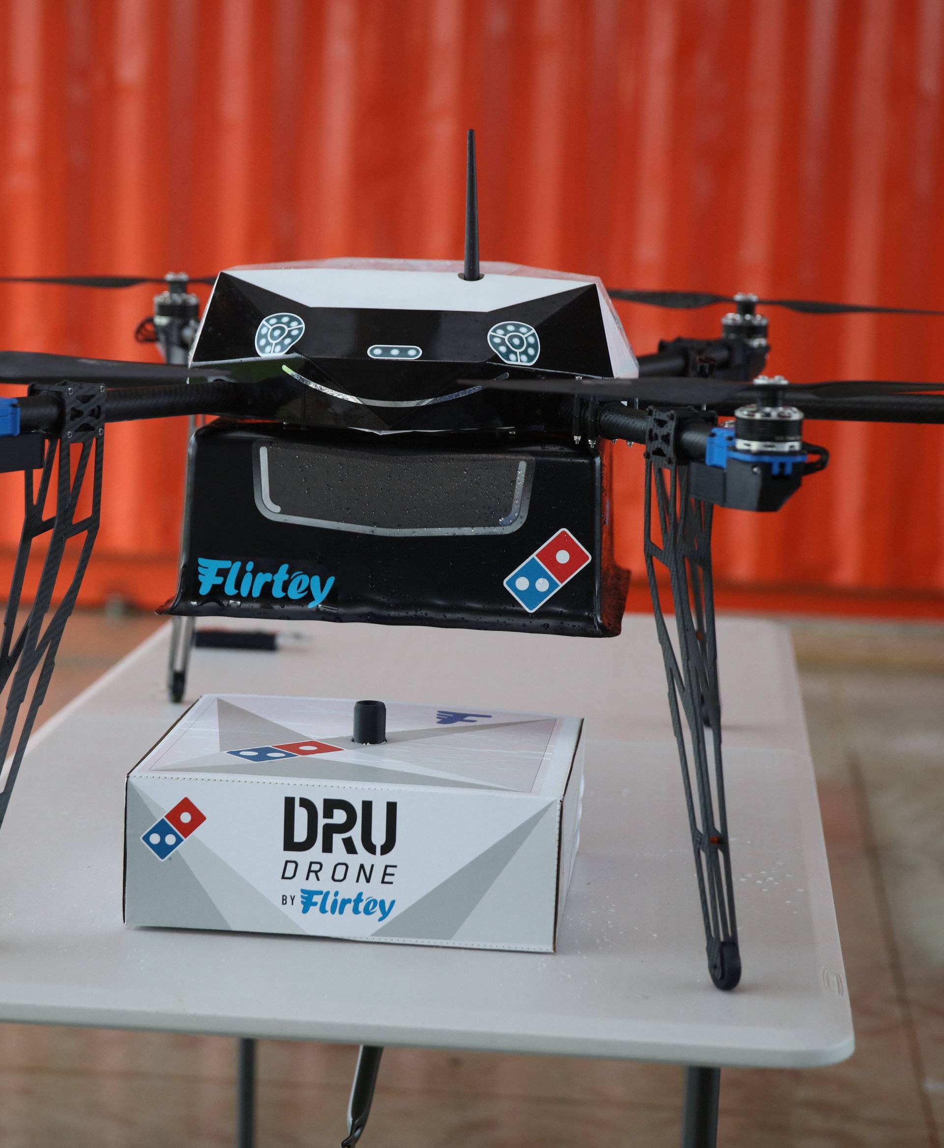 A pizza delivery drone sits with a pizza box underneath before a test flight in Auckland, New Zealand