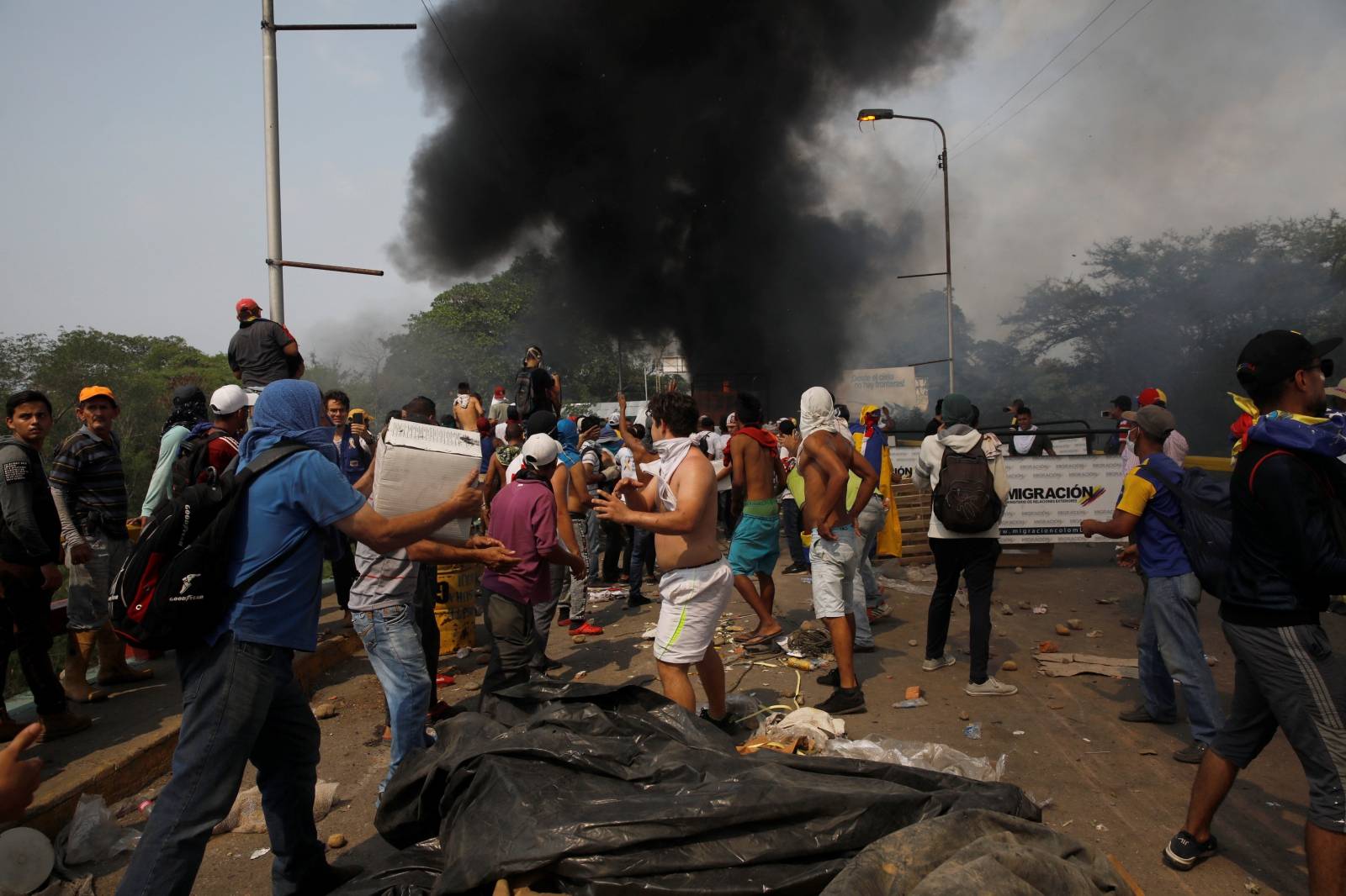 Opposition supporters unload humanitarian aid from a truck that was sent on fire in Cucuta