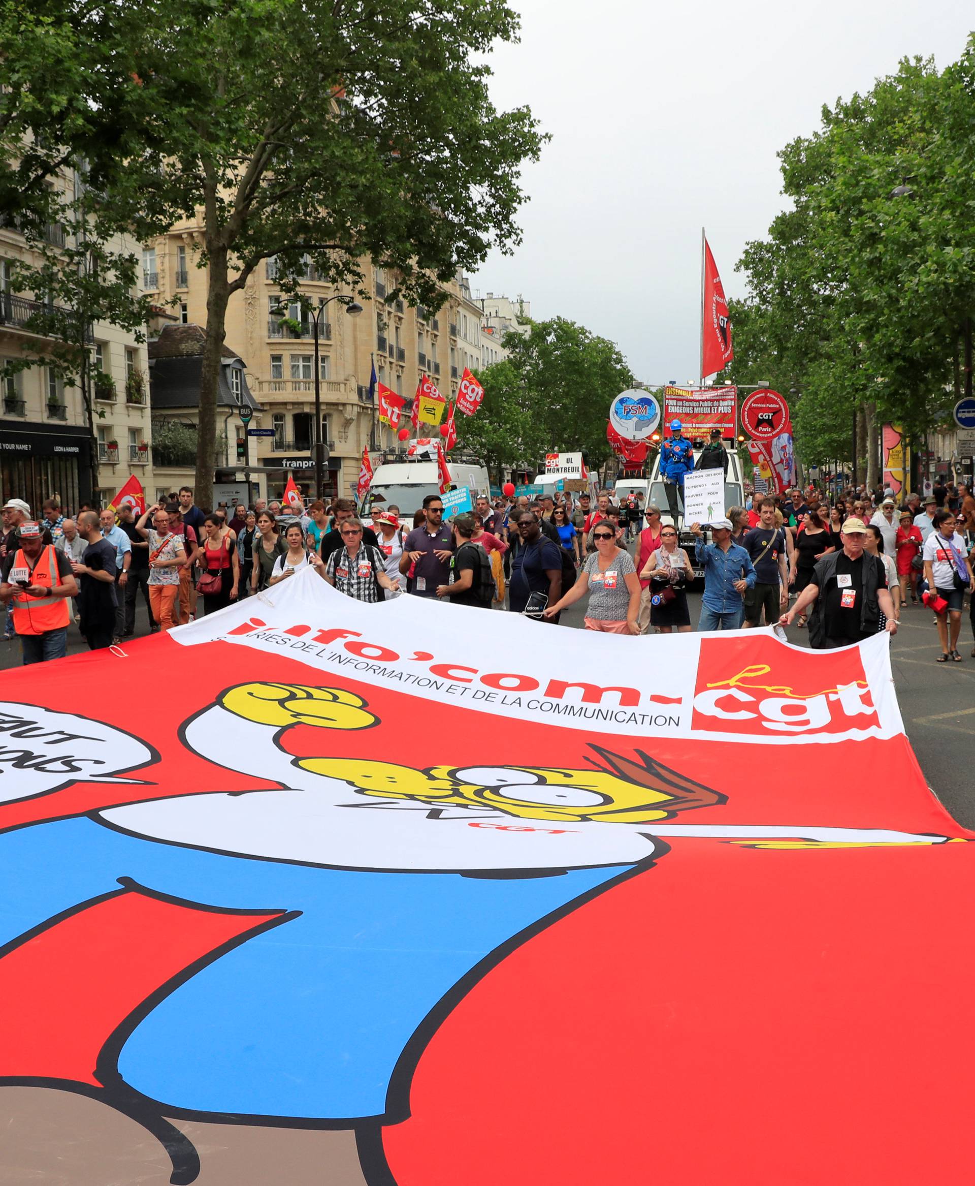 Protesters walk behind a giant banner during a demonstration by French unions and France Insoumise" (France Unbowed) political party to protest against government reforms, in Paris