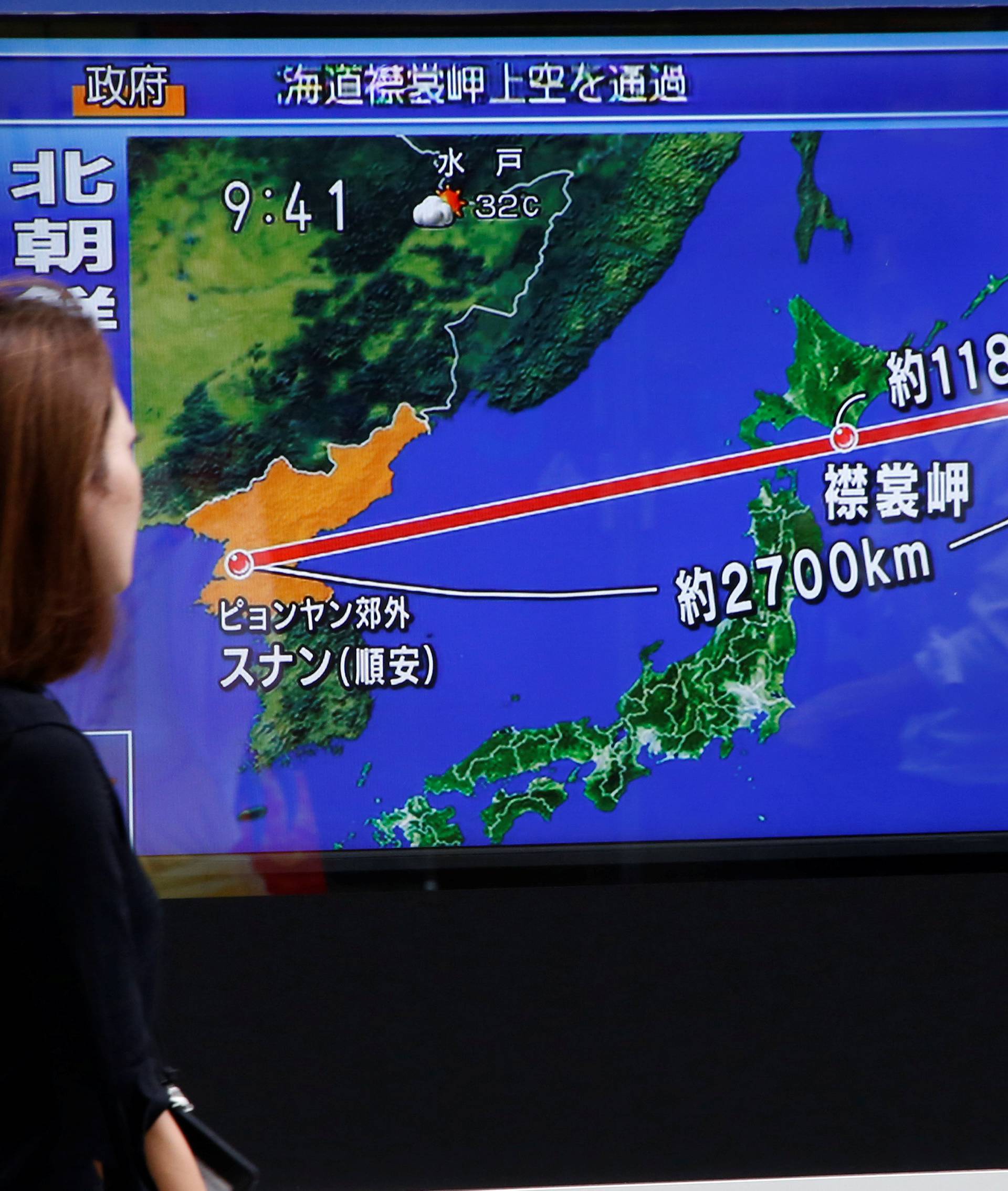 Pedestrians walk past a TV set showing news about North Korea's missile launch in Tokyo