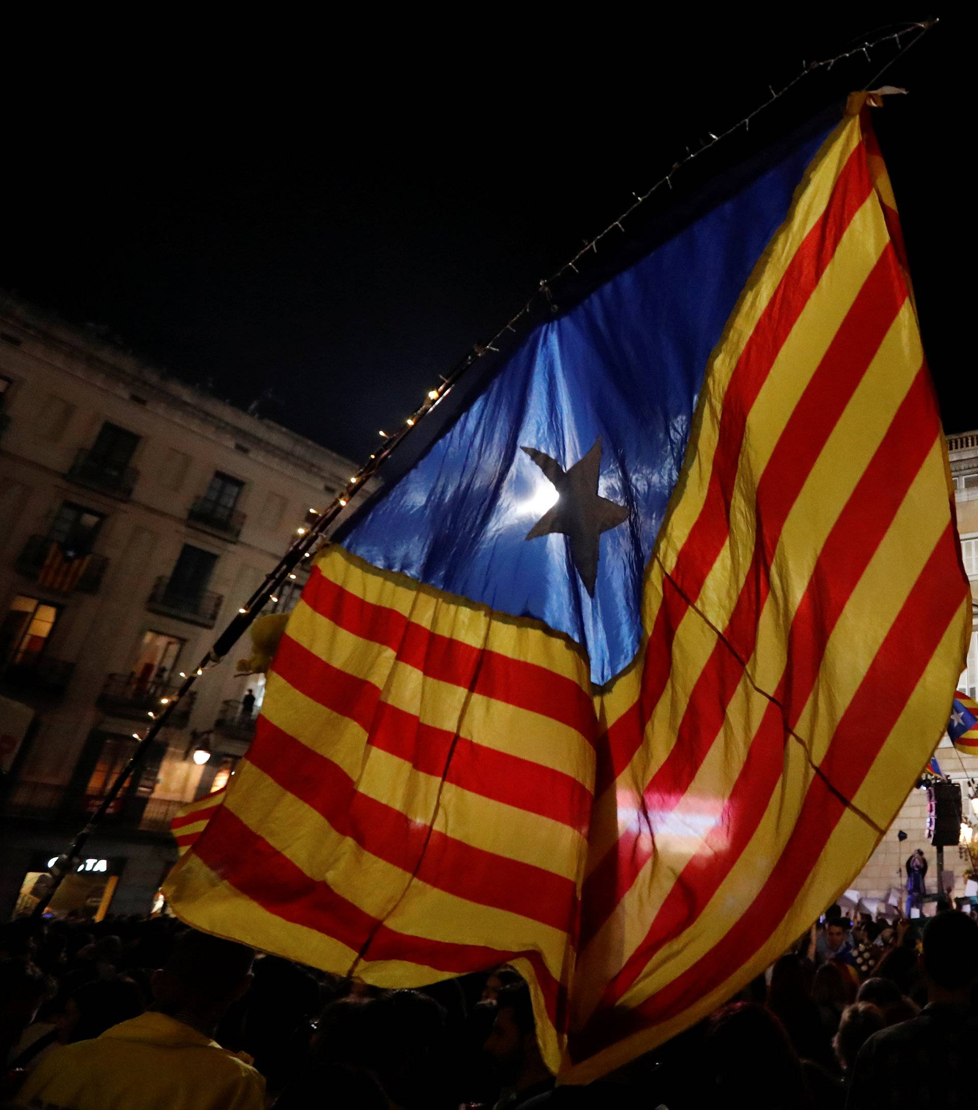 People celebrate and wave Catalan separatist flags in Sant Jaume square after the Catalan regional parliament declared independence from Spain in Barcelona