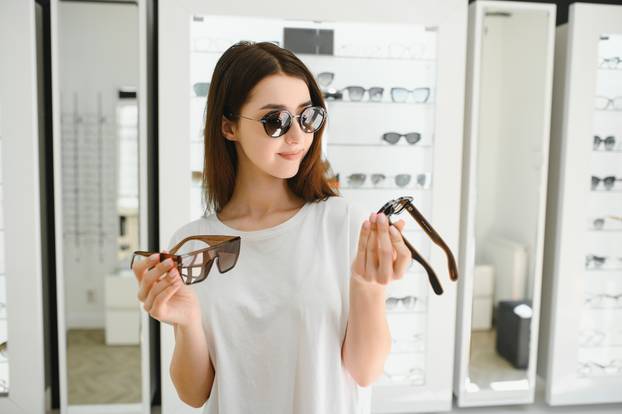 A,Young,Woman,Chooses,On,Sunglasses,In,An,Optics,Store.