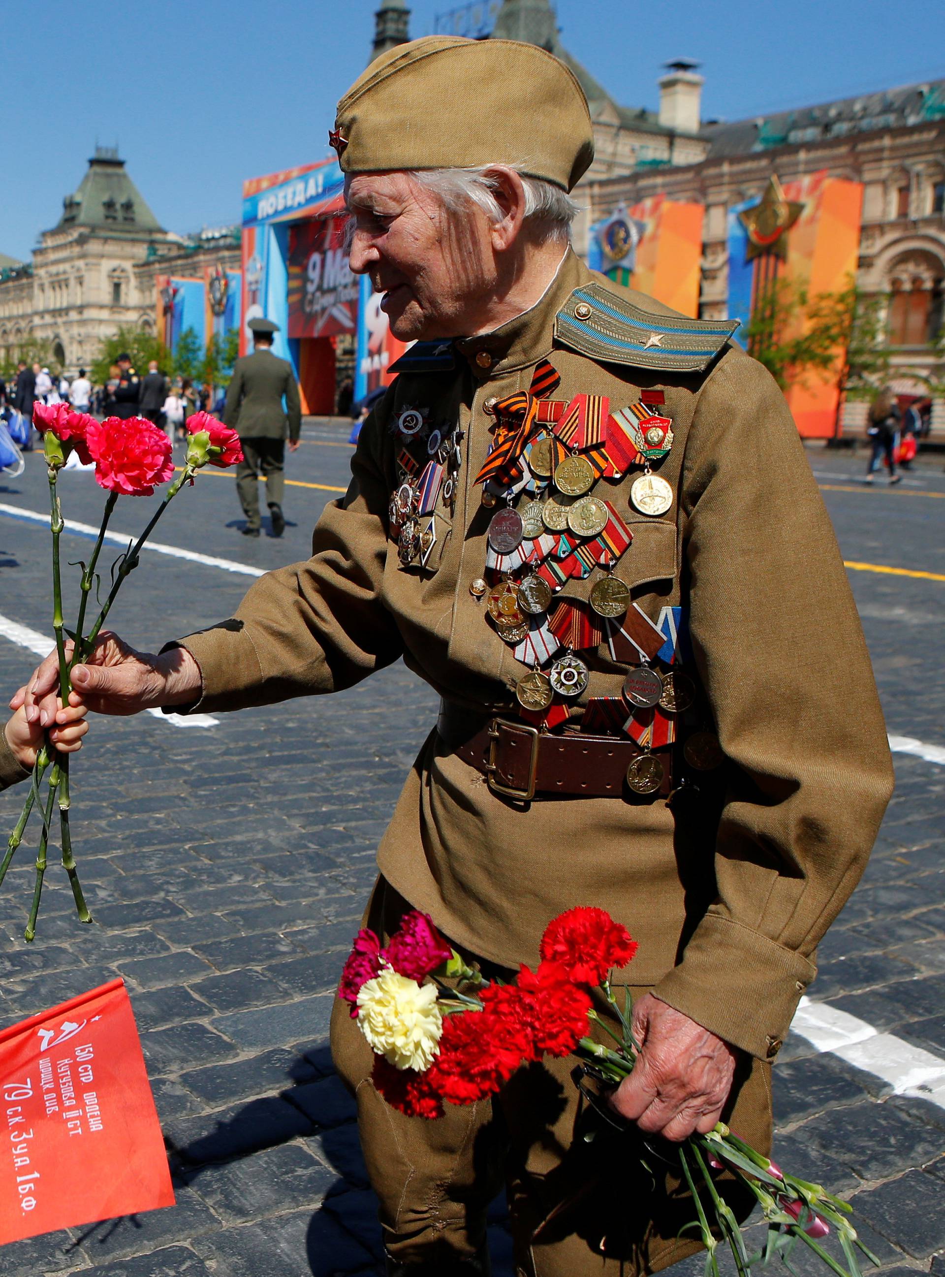 A veteran recives a red rose from a girl during the Victory Day celebrations at the Red Square in Moscow